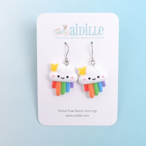 May include: A pair of nickel-free button earrings featuring a white cloud with a rainbow and a yellow star. The earrings are on a white card with the text "aidille handmade accessories for you & your home" and "Nickel Free Button Earrings www.aidille.com".