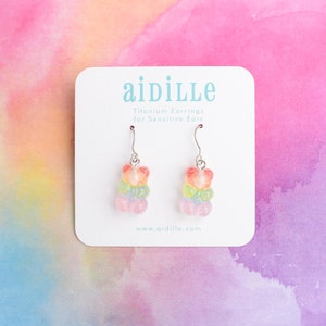 May include: Rainbow gummy bear dangle earrings on a white card with the text "aidille Titanium Earrings for Sensitive Ears www.aidille.com"