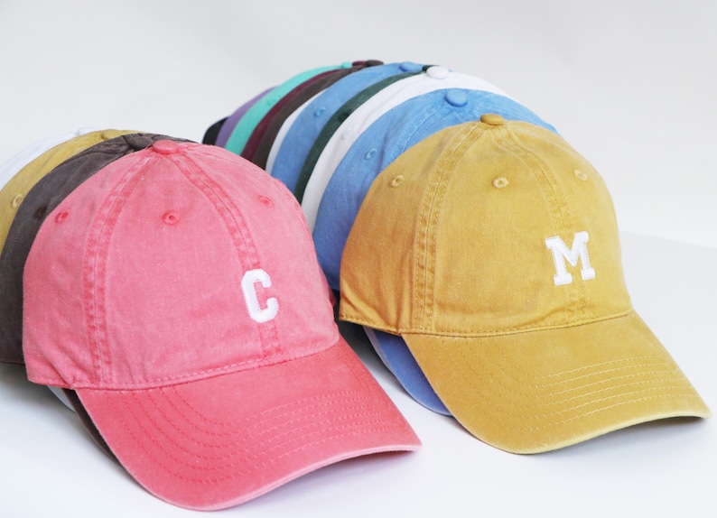 Peut inclure: Plusieurs casquettes de baseball de couleurs vari&eacute;es, rose, jaune, bleu et marron. Les casquettes ont un design classique avec une visi&egrave;re incurv&eacute;e et une sangle r&eacute;glable. Certaines casquettes affichent une lettre blanche sur le devant.