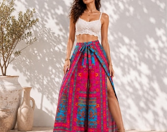 May include: A white lace crop top with thin straps and a sweetheart neckline paired with high-waisted wide-leg pants featuring a vibrant pink, blue, and orange geometric pattern, a tie-front waist detail, and high side slits on both legs.