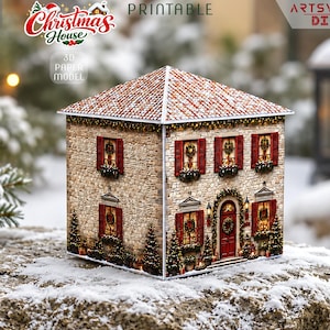 May include: A 3D paper model of a two-story stone house with a snow-covered roof, red shutters, and festive Christmas decorations including wreaths and garlands. The structure features a central red door and multiple windows with warm lighting.