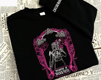 May include: Black sweatshirt with a pink and white graphic of a figure holding a sword, framed by floral accents. The text "DAUGHTER OF DARKNESS" is below the figure. The word "SHADOWHEART" is printed on the sleeve.