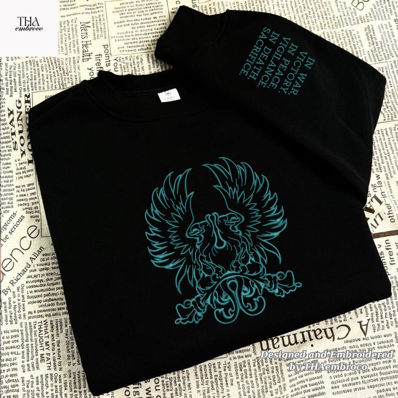 May include: Black sweatshirt with a teal phoenix emblem. The sleeve has the text "IN WAR, VICTORY. IN PEACE, VIGILANCE. IN DEATH, SACRIFICE." Designed and embroidered by Thaembroco.