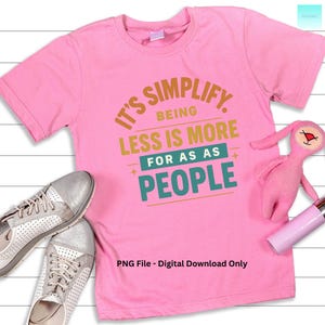Puede incluir: Una camiseta rosa con el texto "It's Simplify, Being Less Is More For As As People" en varios colores. La imagen también muestra zapatillas plateadas, un peluche rosa y un pintalabios rosa. También es visible el texto "PNG File - Digital Download Only".