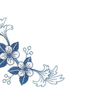 May include: Blue and white floral embroidery design with a corner motif. The design features two flowers with five petals each, surrounded by leaves and stems.