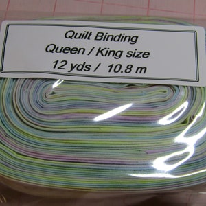 Könnte beinhalten: Eine Rolle pastellfarbener Quilt-Binde in einer durchsichtigen Plastiktüte. Das Etikett lautet "Quilt Binding Queen / King size 12 yds / 10.8 m".
