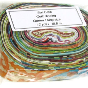 Op de afbeelding: Een rol kleurrijke Bali batik quilt binding in een doorzichtige plastic zak. Het label vermeldt "Bali Batik Quilt Binding Queen / King size 12 yds / 10.8 m".