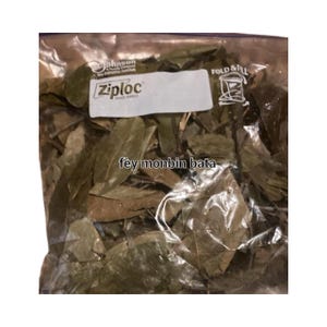 May include: A clear Ziploc bag filled with dried green leaves. The bag has a white label with the Ziploc brand name and the text "fey monbin bata" printed on it. The bag is sealed and ready for use.