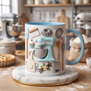Może przedstawiać: Biały ceramiczny kubek z jasnoniebieskim wnętrzem i uchwytem, ozdobiony ilustracjami o tematyce piekarniczej. Zawiera mikser stojący, babeczkę i inne przybory kuchenne. Kubek stoi na marmurowej podstawce ze złotą obwódką. Na kubku widnieje napis "Name".