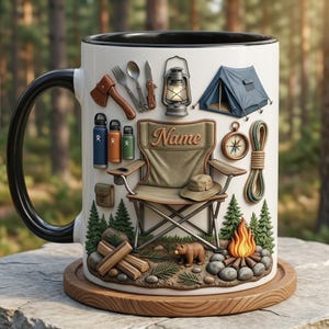 Puede incluir: Taza de cerámica blanca con asa y borde negros, con ilustraciones de temática de camping. Incluye una tienda de campaña, una silla, una linterna y una escena de fogata con un oso. La taza tiene la palabra "Name".