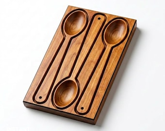 May include: A rectangular wooden board featuring three carved, recessed slots shaped like spoons. The board has a warm, medium-brown wood grain finish. Two of the slots are oriented with the bowl at the top, while one is oriented with the bowl at the bottom.