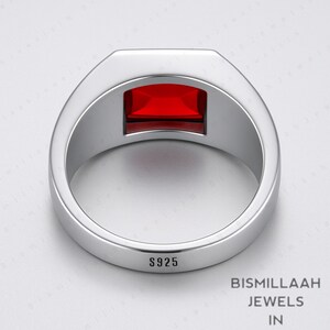 Puede incluir: Un anillo plateado con una gema rectangular de color rojo intenso. El anillo est&aacute; estampado con "S925" y tiene un acabado pulido. El anillo es de "Bismillaah Jewels".