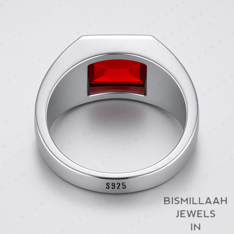 Puede incluir: Un anillo plateado con una gema rectangular de color rojo intenso. El anillo est&aacute; estampado con "S925" y tiene un acabado pulido. El anillo es de "Bismillaah Jewels".
