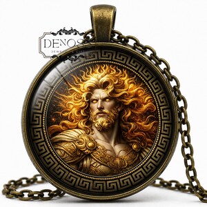 Puede incluir: Un colgante redondo de tono bronce con el retrato de una figura de largo cabello dorado y barba sobre un fondo oscuro. El marco está decorado con un patrón de greca en negro y bronce e incluye una cadena metálica a juego.