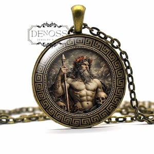 Puede incluir: Un colgante redondo de tono bronce con un borde de greca y una imagen central de una figura barbuda con corona que sostiene un bastón junto a una calavera. El texto DENOSS JEWELRY & GIFTS aparece en la esquina superior izquierda.
