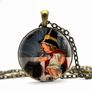 May include: A round pendant necklace featuring a bronze-toned metal frame and chain. The circular glass cabochon displays a vintage-style illustration of a child wearing a black pointed hat and red cape, stirring a black cauldron with a spoon.