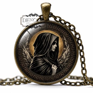 May include: A round bronze-toned pendant necklace featuring a glass cabochon with an illustration of a hooded figure with wings. The border displays a black and bronze Greek key pattern. The text DENO JEWELRY & GIFT is visible in the upper left.