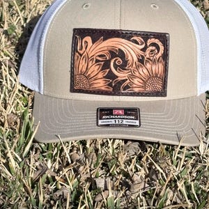 Chapeaux avec écusson en cuir véritable travaillé.