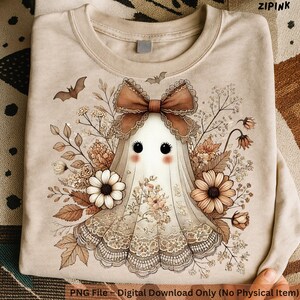 May include: Beige sweatshirt featuring a whimsical ghost design with a brown bow, floral accents, and lace details. The ghost has large black eyes and rosy cheeks. The text "ZIPINK" is visible in the upper right corner. The bottom of the shirt reads "PNG File - Digital Download Only (No Physical Item)".