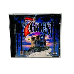 May include: A CD-ROM case featuring the game "The 7th Guest." The cover art depicts a spooky mansion on a hill, with a dark blue sky and lightning. The game title is in a bold, red font. The case is in a clear plastic.