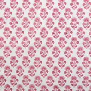 Könnte beinhalten: Weißer Stoff mit einem sich wiederholenden Muster aus rosa floralen Designs. Jedes florale Element weist eine zentrale Blüte mit umgebenden Blütenblättern und Blättern auf, wodurch ein symmetrischer und optisch ansprechender Stoff entsteht.