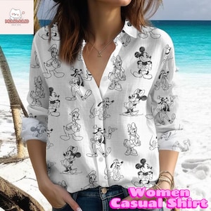 May include: White button-down shirt featuring a black and white cartoon character print. The shirt has long sleeves and a V-neck. The text "Women Casual Shirt" is visible on the bottom right.