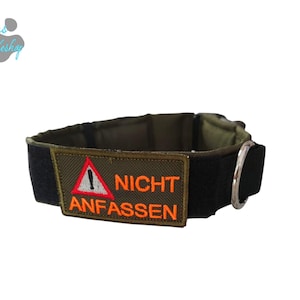 Könnte beinhalten: Olivgrünes und schwarzes Hundehalsband mit einem silbernen Metallring. Das Halsband hat ein rechteckiges Patch mit einem roten Warndreieck-Symbol und den Worten "NICHT ANFASSEN" in Orange. Für Hunde.