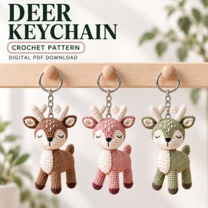May include: Three crochet deer keychains in brown, pink, and green, each with white antlers and a cream-coloured chest. The text DEER KEYCHAIN CROCHET PATTERN DIGITAL PDF DOWNLOAD is visible above the keychains hanging from a wooden rack.