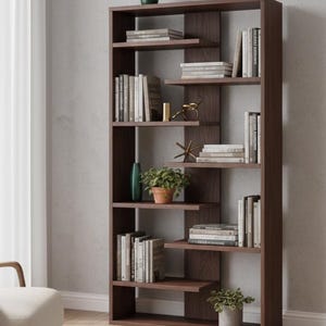 May include: A dark brown wooden bookshelf with multiple shelves of varying sizes. The shelves are filled with books, decorative vases, and a potted plant. The bookshelf is against a light gray wall.