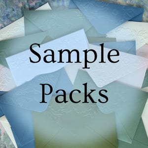 May include: An assortment of sample packs of envelopes in various shades of blue and white. The envelopes have embossed floral designs. The words "Sample Packs" are printed in black across the center of the image.