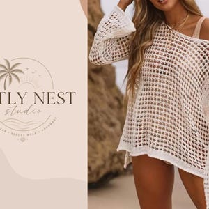 Könnte beinhalten: Cremefarbener Strand-Cover-up mit offenem Gewebe und langen, ausgestellten Ärmeln. Das Cover-up ist Teil der Artly Nest Studio-Kollektion, die Strandmode, Resortmode und handgefertigte Artikel umfasst. Das Logo zeigt eine Palme, eine Sonne und den Markennamen.