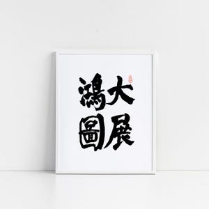 Puede incluir: Una obra de arte enmarcada con caligrafía negra sobre fondo blanco. La caligrafía incluye cuatro caracteres chinos y un pequeño sello rojo. El marco es blanco.