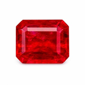 May include: A vibrant red gemstone with a rectangular emerald cut, featuring sharp beveled edges and a faceted surface that reflects light. The stone displays a deep, saturated crimson hue with internal clarity and a polished, glossy finish.