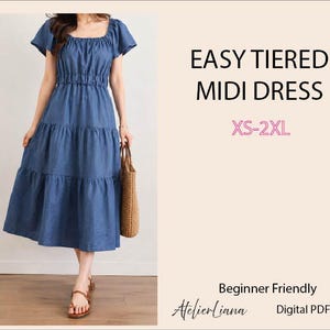 May include: A blue midi dress with short flutter sleeves, a square neckline, and a tiered skirt. The text reads EASY TIERED MIDI DRESS, XS-2XL, Beginner Friendly, AtelierLiana, and Digital PDF Pattern. The dress features a gathered waistline.