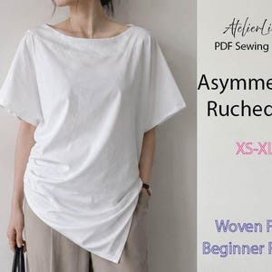 May include: A white asymmetrical ruched top with short sleeves and a wide neckline. The text on the right reads AtelierLiana PDF Sewing Pattern, Asymmetrical Ruched Top, XS-XL, Woven Fabric, Beginner Friendly. The top has a gathered side detail.