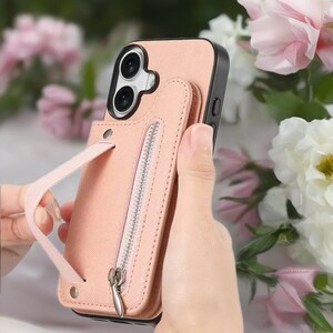 May include: A pink phone case with a black border and a matching wallet attachment. The wallet has a zipper closure and a wrist strap. The phone case is shown against a background of pink and white flowers.