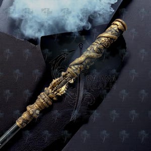 Puede incluir: Bastón ornamentado de estilo antiguo con un detallado motivo de dragón en tonos dorados y bronce. El bastón presenta intrincadas tallas y un agarre texturizado. El texto "KATANA REALM" es visible en el fondo.