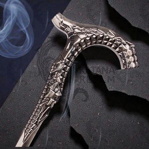 May include: A silver-colored walking cane with intricate geometric and sculpted designs. The handle features a curved, diamond-patterned grip. The shaft is detailed with a repeating pattern. The background is dark with a smoky effect.