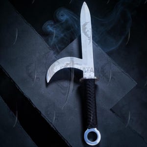 May include: A silver-colored, curved blade knife with a black wrapped handle and a circular pommel. The blade has a decorative etching. The knife is displayed against a dark background with a subtle smoky effect.