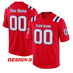 Puede incluir: Dos camisetas deportivas rojas con n&uacute;meros y letras blancas. Una camiseta muestra "Your Name" y el n&uacute;mero "00" en la espalda. La otra camiseta muestra "TEAM NAME" y "00" en la parte delantera. Rayas azules y blancas acent&uacute;an los hombros. El texto "DESIGN 3" est&aacute; en la parte inferior.