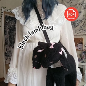 Peut inclure: Un sac bandoulière en peluche noire en forme d'agneau à deux têtes, avec des accents roses sur les oreilles et les museaux, et une sangle noire réglable. Le texte "black lamb bag" est écrit en police gothique et une icône rouge "PDF" est visible.
