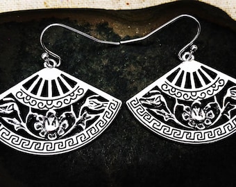 May include: A pair of silver-coloured fan-shaped earrings. Each earring has a detailed black floral design with a Greek key border. The top section has a sunburst pattern.