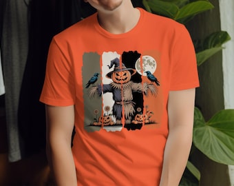 Könnte beinhalten: Orangefarbenes T-Shirt mit einem Halloween-Motiv. Das Design zeigt eine Vogelscheuche mit einem Kürbiskopf, Krähen, Kürbissen und einem Vollmond. Die Vogelscheuche ist vor einem Hintergrund aus vertikalen Farbblöcken platziert.
