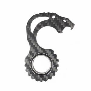 May include: A carbon fiber bottle opener with a jaguar head design. The opener has a circular base with a gear-like pattern and a curved handle. The carbon fiber material has a woven texture.