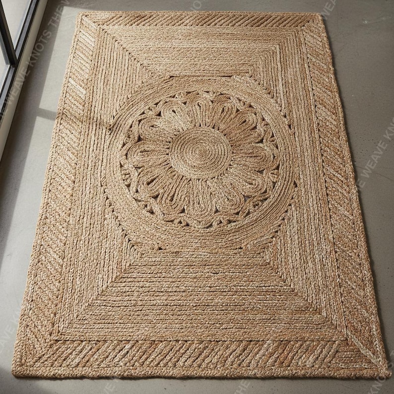 Full angled view custom braided jute area rug with central floral motif on gray floor modern style.