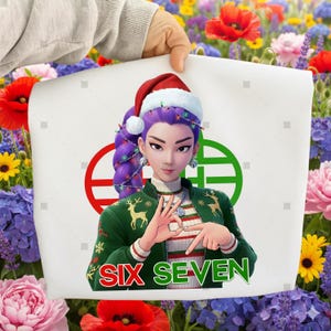Puede incluir: Una impresión rectangular blanca con un personaje de dibujos animados que lleva un gorro de Papá Noel y una chaqueta verde con diseños de ciervos. La impresión incluye el texto "SIX SEVEN" en verde y rojo. El personaje tiene pelo morado.