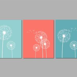 May include: Three square canvases with a light blue, coral, and light blue background. Each canvas features a white dandelion with seeds blowing in the wind.