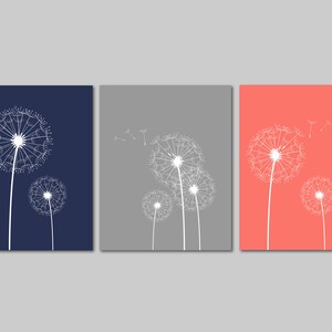 以下が含まれることがあります： 白いタンポポのイラストが描かれた正方形のキャンバスが3枚。キャンバスの色はネイビーブルー、グレー、コーラルです。