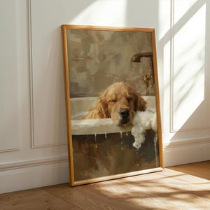 Op de afbeelding: Een ingelijste print van een golden retriever die ontspant in een badkuip vol bubbels. De hond heeft zijn ogen gesloten. Het kunstwerk heeft een warme, vintage esthetiek met een gouden lijst.