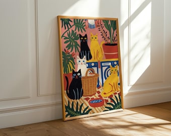 Può includere: Una stampa artistica incorniciata raffigurante sei gatti stilizzati in una lavanderia. I gatti sono neri, bianchi e gialli, su uno sfondo rosa con piante verdi. Sono visibili anche un cestino di vimini e una ciotola rossa e blu.